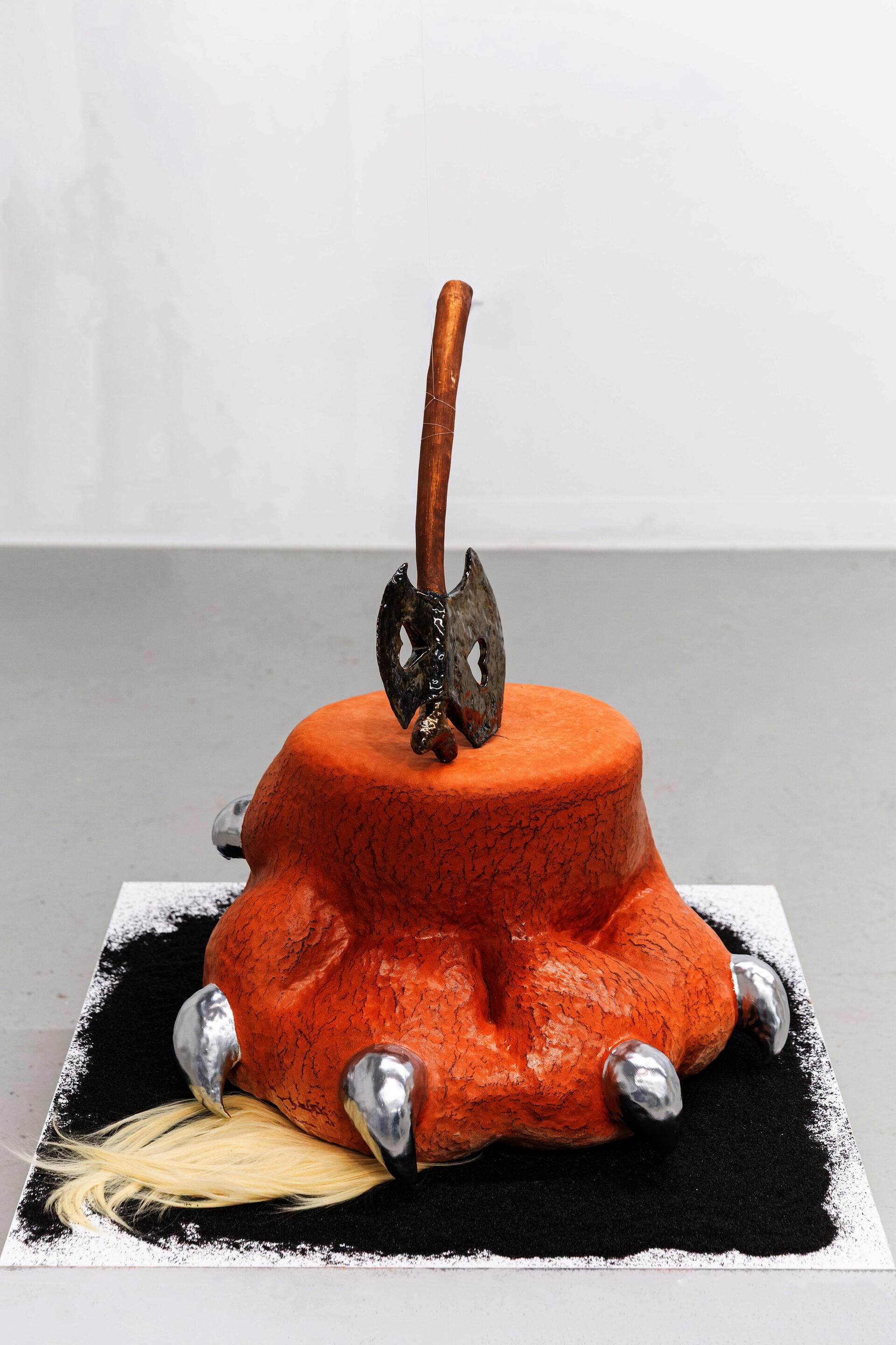 Claw-shaped stump sculpture with metallic glaze and a tuft of fur at the base. Ceramic form sits between plant and creature, combining soft and sharp elements to create tension and ambiguity.