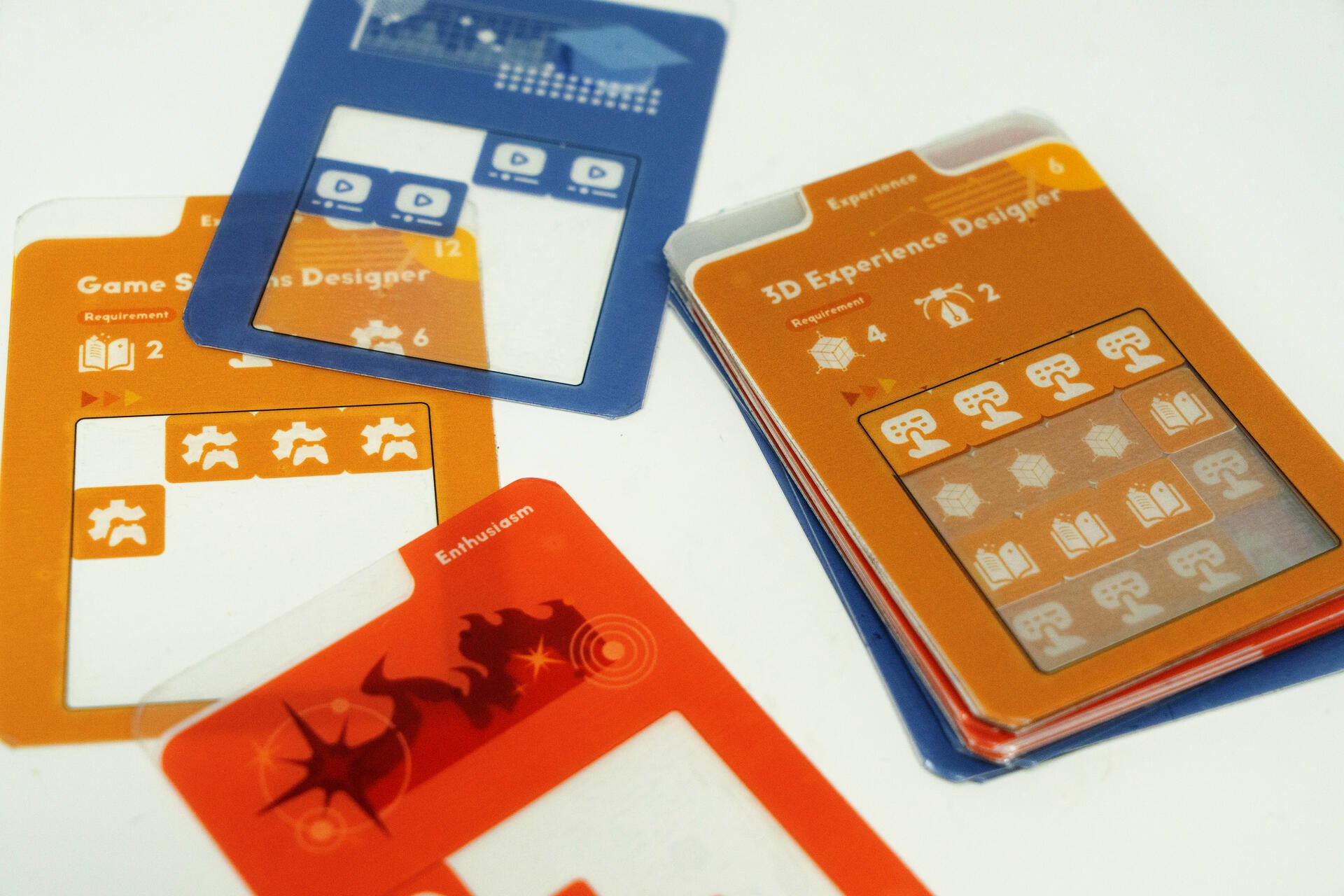 Transparent overlay cards placed on colorful job-description cards in a tabletop board game prototype about resume-building, persuasive communication, and role-play.
