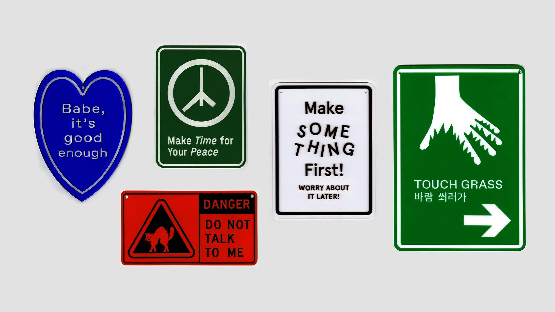 A display of five plastic signages in various colors. The design is similar to the style of traffic sign. The text on the signs are words of personal reminders and public announcement.