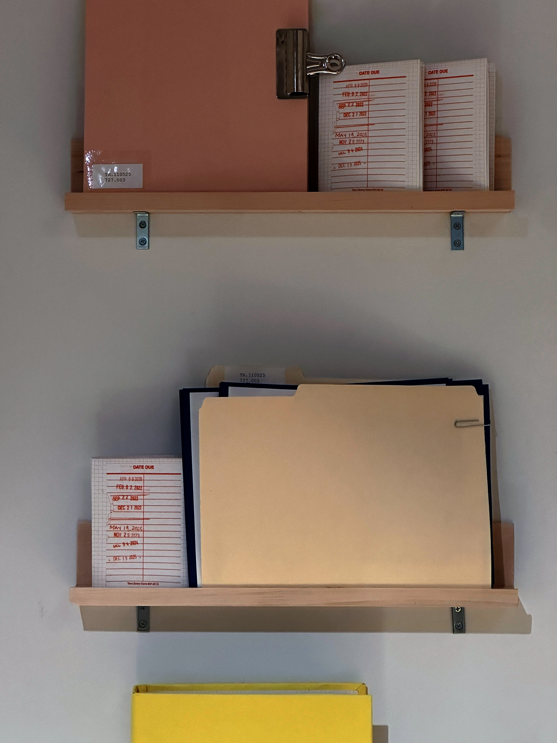 an image of two wooden shelves mounted on a wall with different colored and sized books