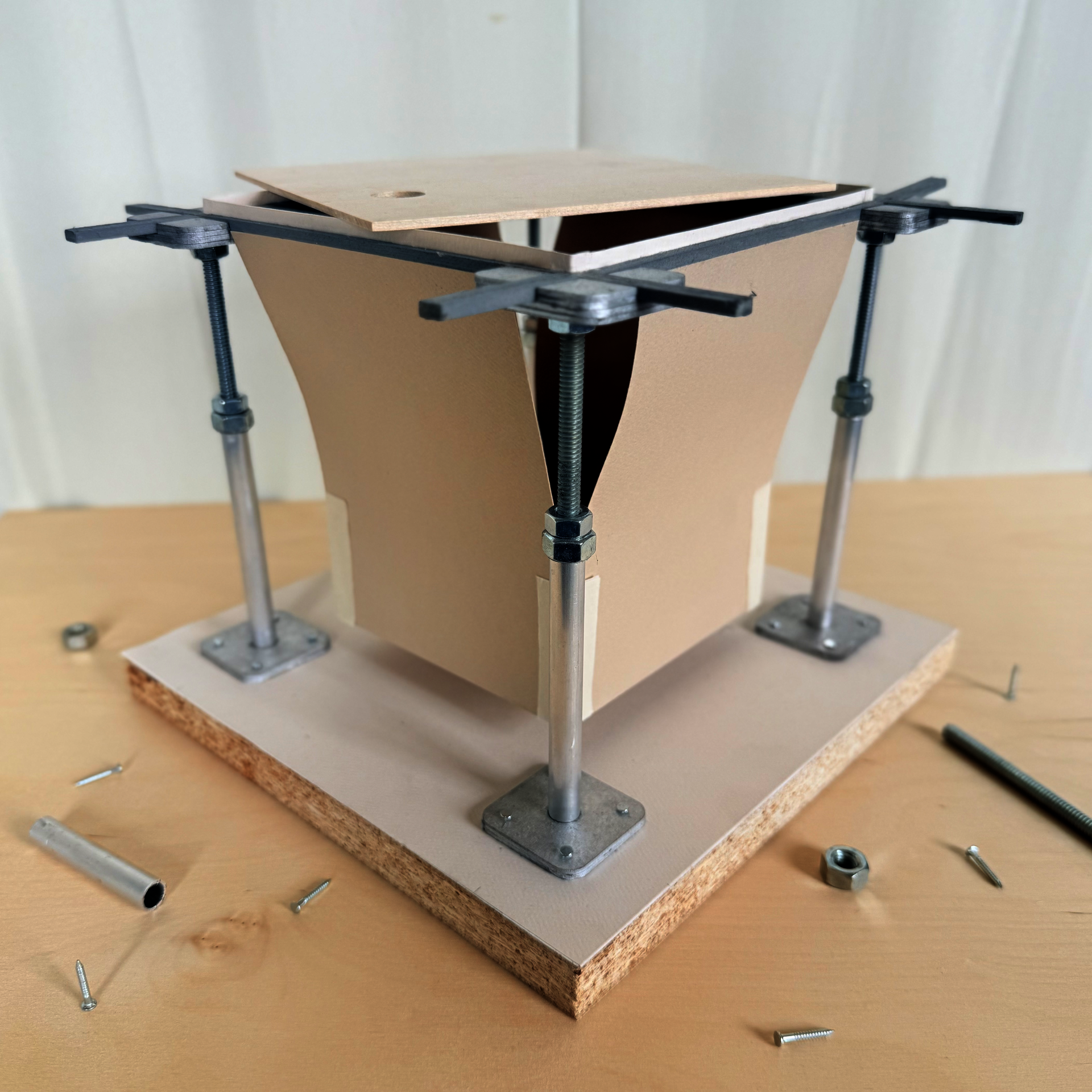 Adjustable metal pedestals on a base support metal stringers holding a wood flooring panel. A storage prototype mounts inside the stringers, and a circular cutout provides access.