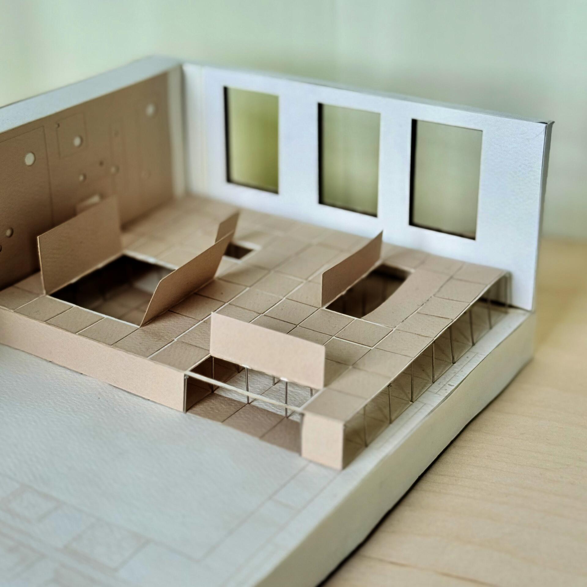 Architectural model showing a raised floor system with cutouts, partitions, and windows, revealing underfloor space and structural supports.