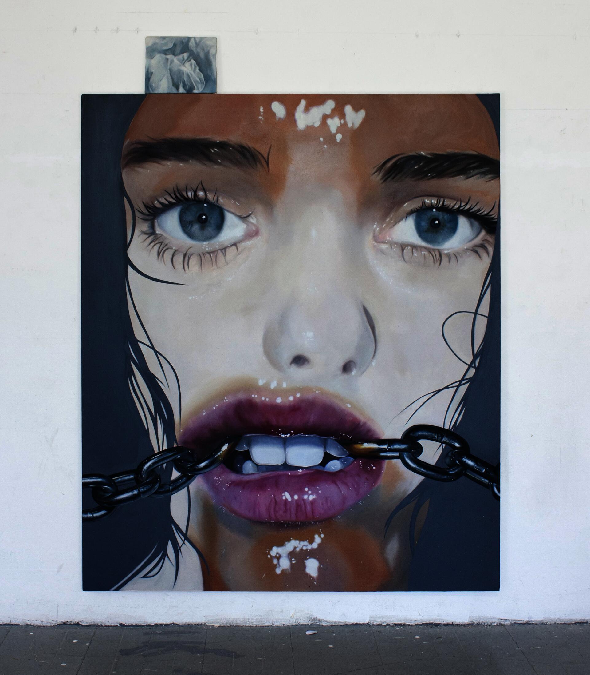 Large, close-up oil painted portrait of a woman's face. She has piercing blue eyes and parted lips with a chain extending out from both corners of her mouth.