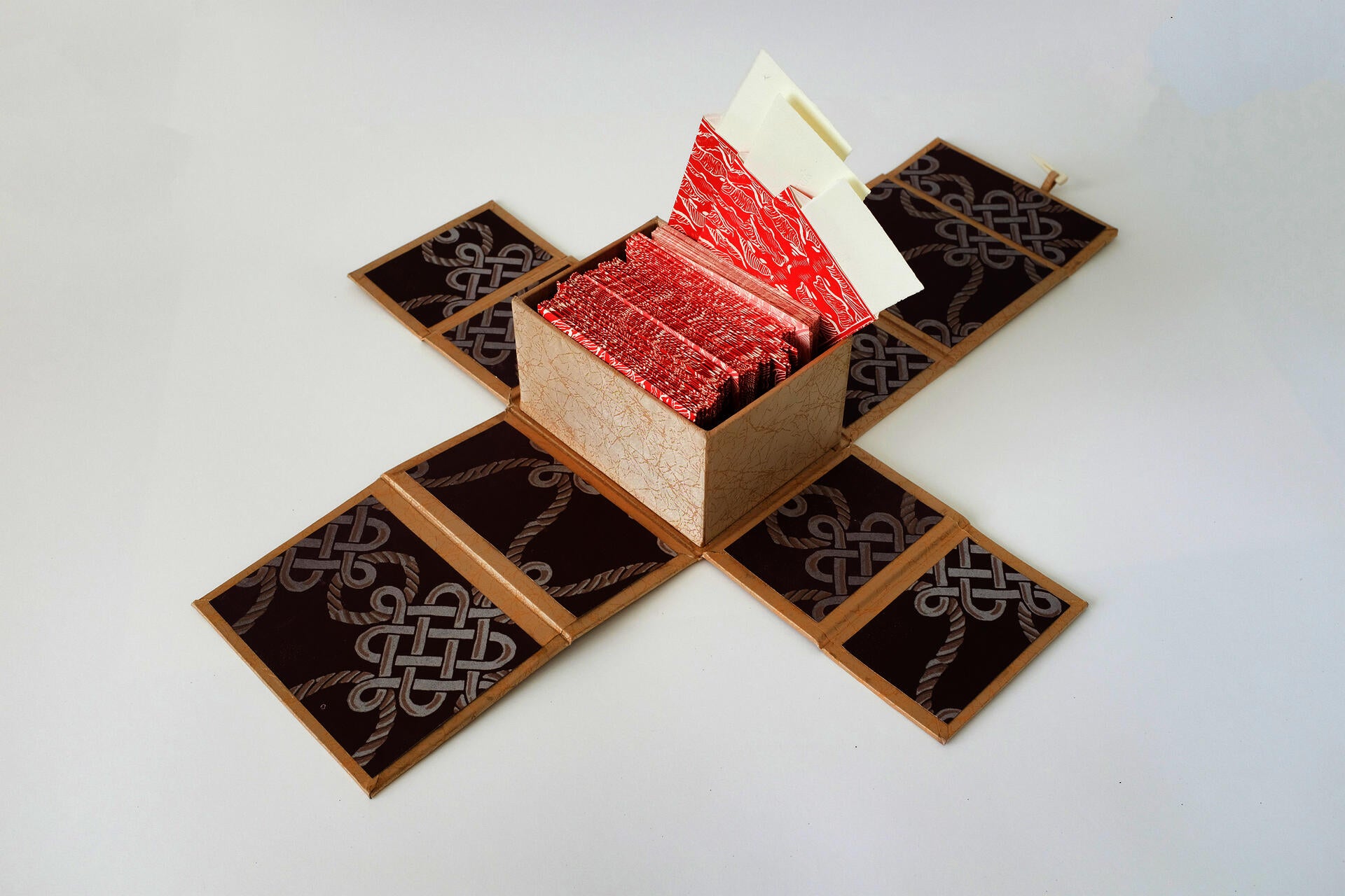 An open box against a white background containing red envelopes. Three envelopes are open and reveal slips of paper inside.