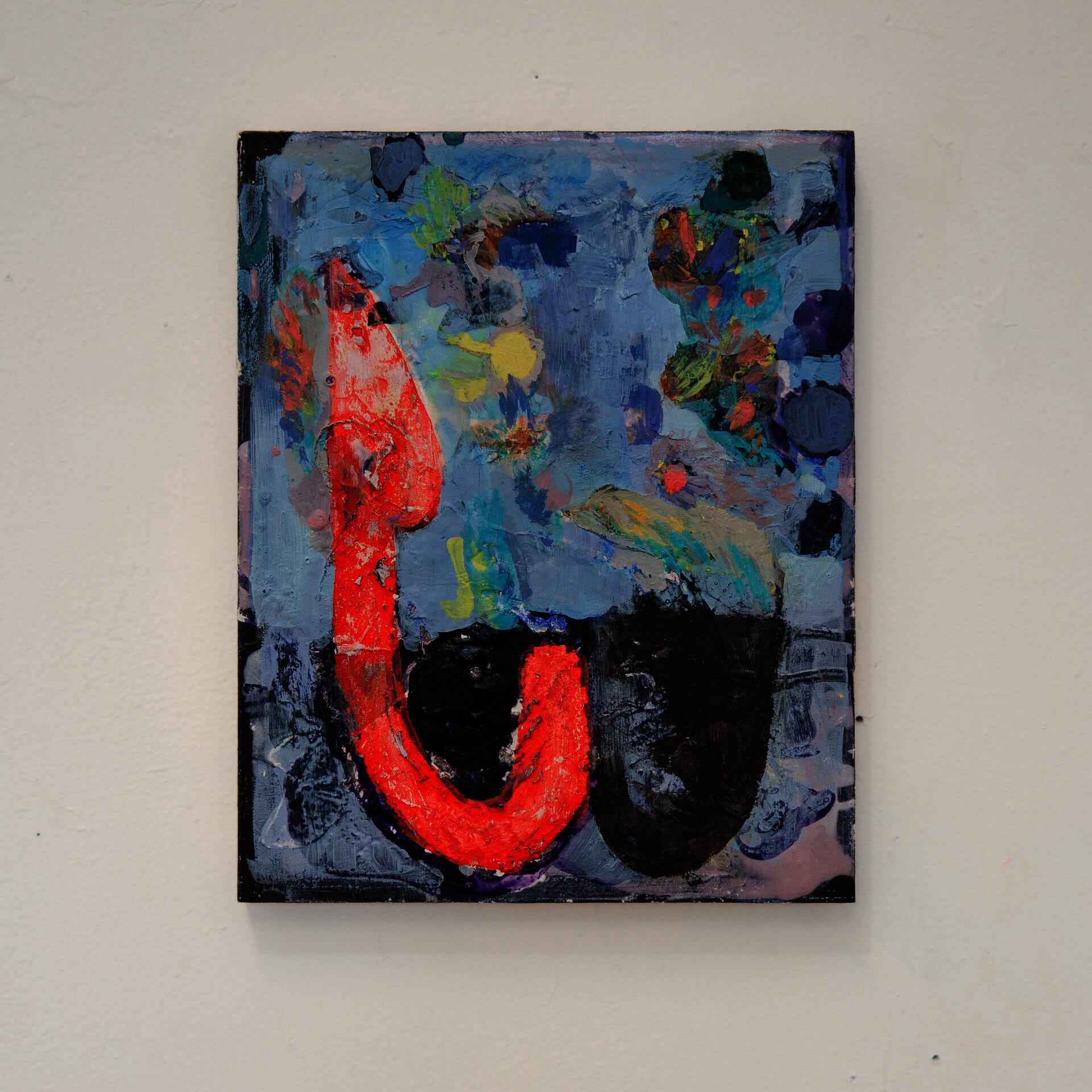 A red hook-like shape stands on a blue field with colorful feather-like paint marks and two dark bowl shapes on the bottom.
