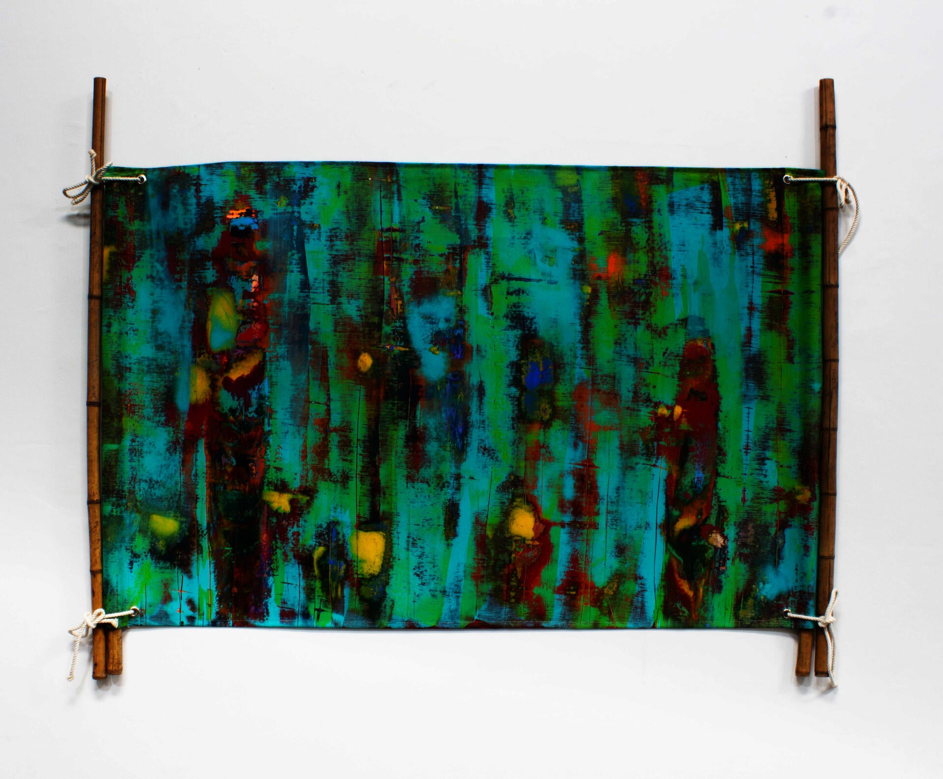 This work represents a painted canvas stitched in a form of wedding tent. attached and hung through bamboo and ropes. 