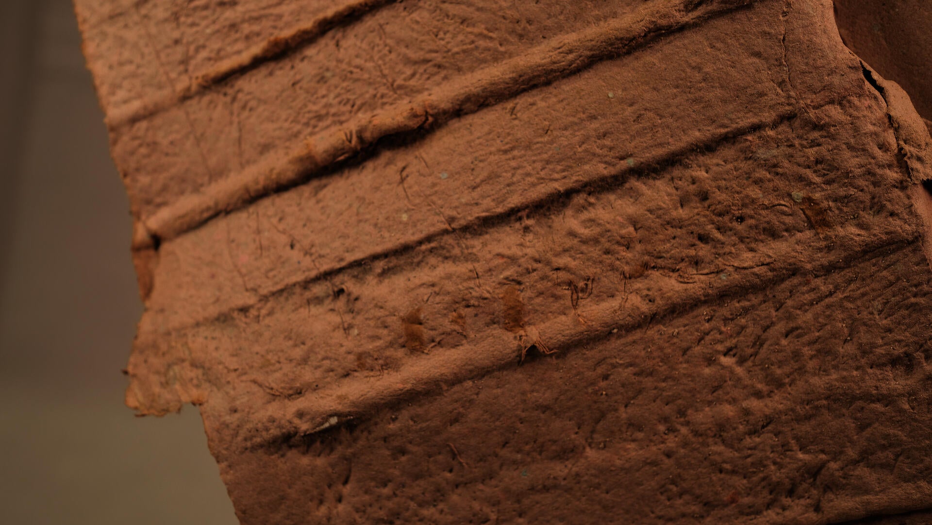 Close-up of a handmade paper cast showing the impressed texture of wooden lathing strips from a historic interior wall.