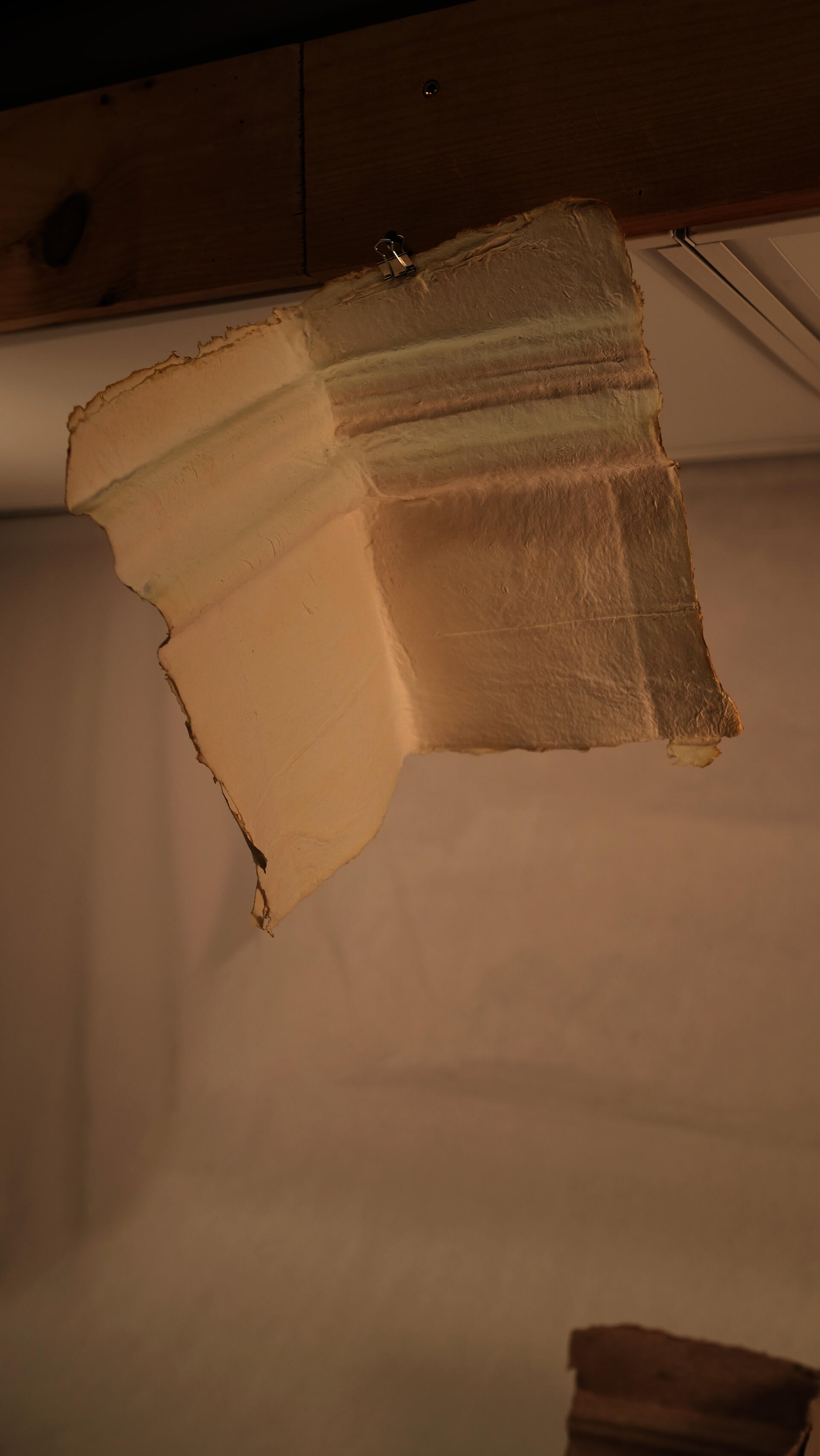A handmade paper trace revealing the profile of a chair rail molding and corner junction from a historic interior wall.