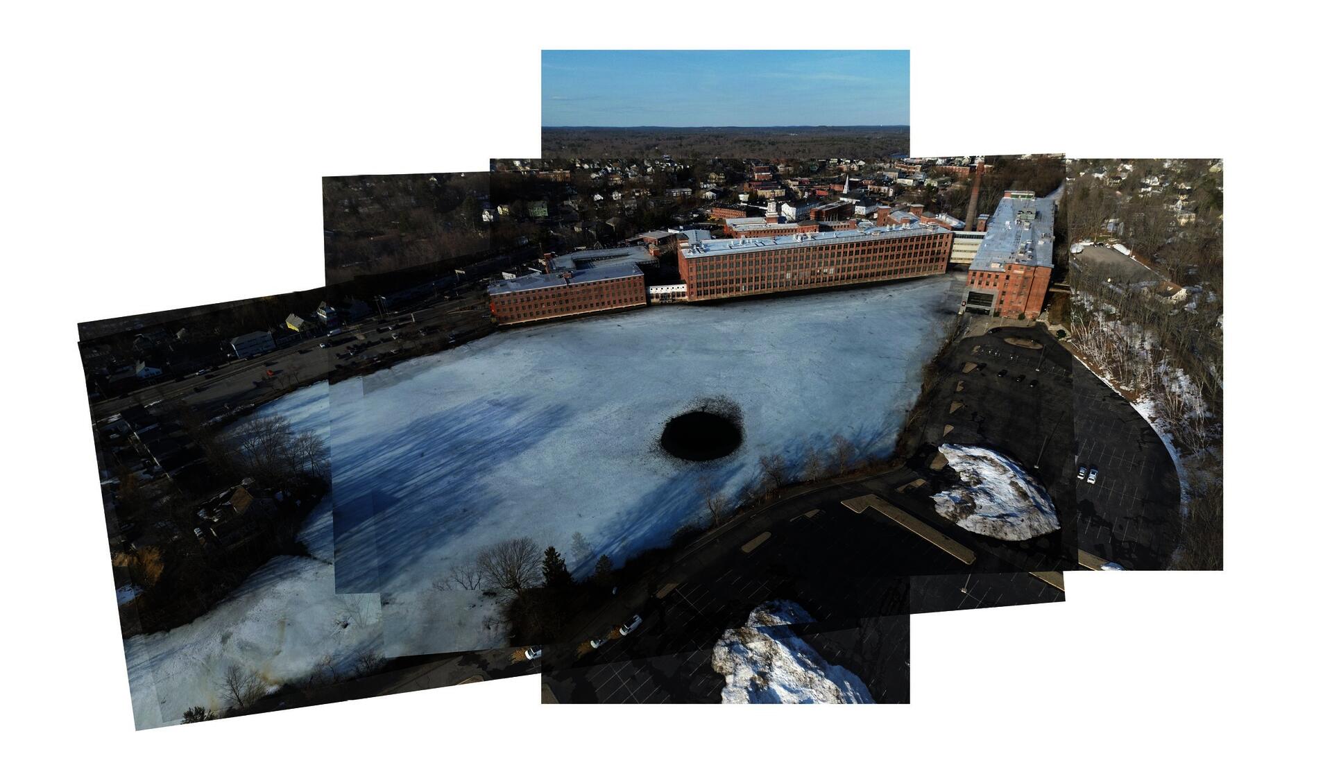 Drone images show the mill complex buildings, pond, and parking lots