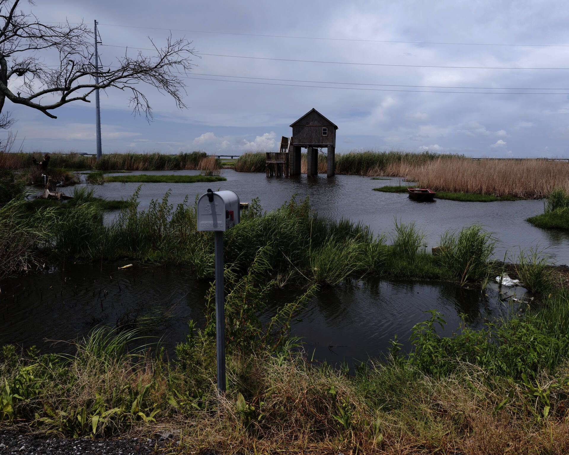 Photograph of an elevated house in South Louisiana. The house is raised on stilts and surrounded by water.