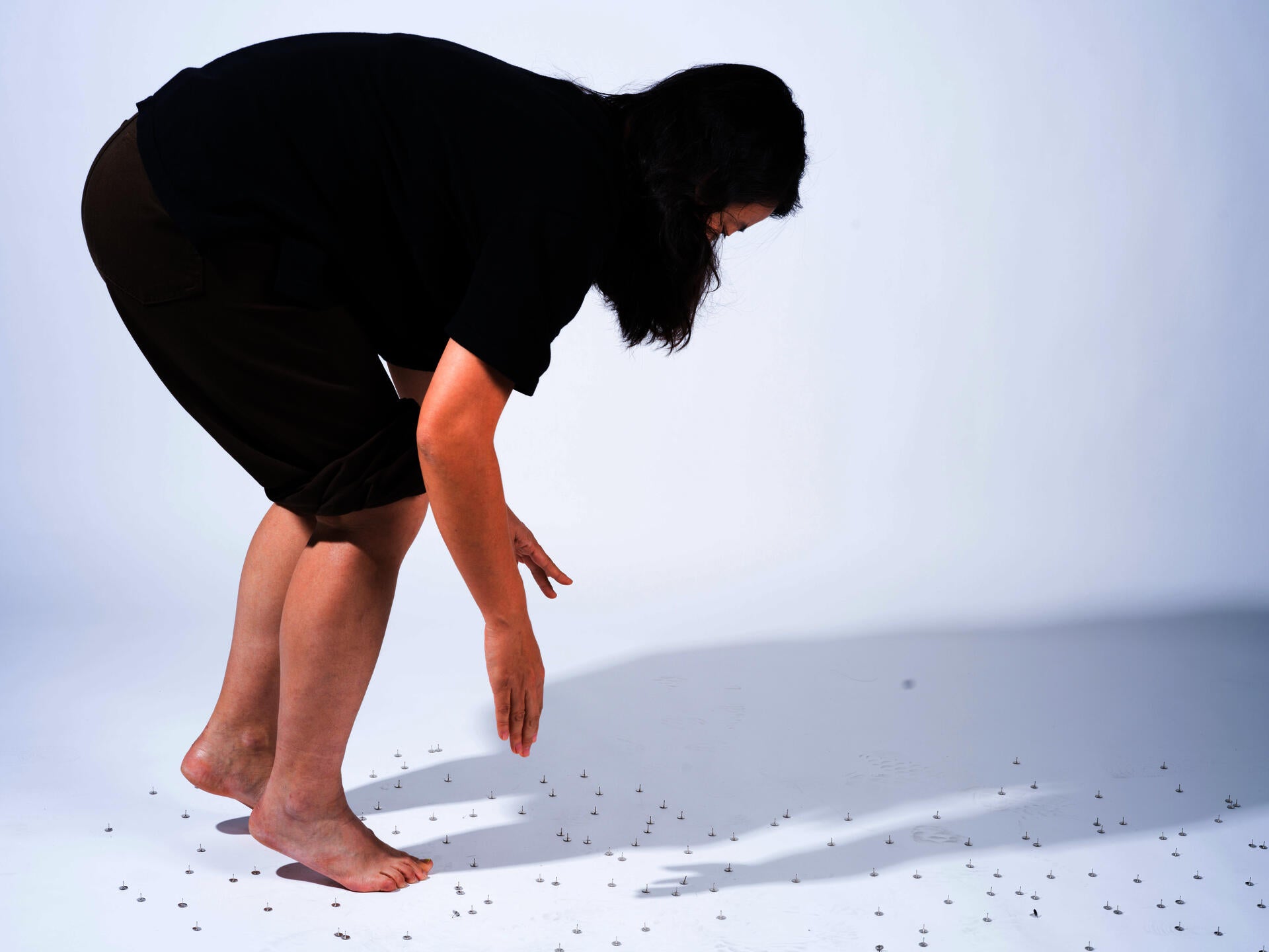 "Nails, 2024 Photography, archival inkjet print This is a studio photograph of the same act — my body crossing a floor of thumbtacks. "
