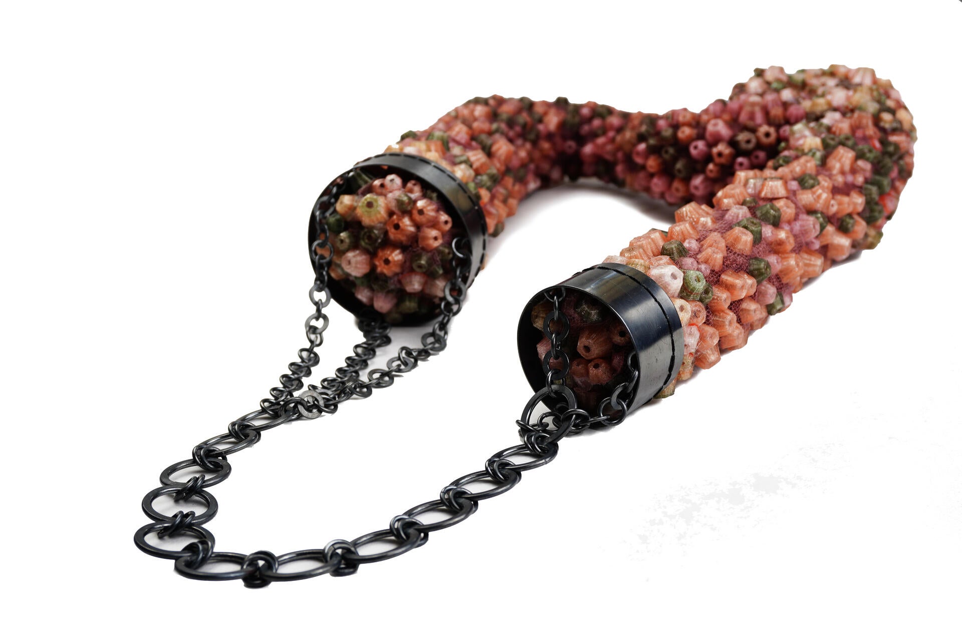 Large necklace covered in dense pink, green, and beige clustered forms on mesh, with an oxidized silver chain wrapping the upper section.