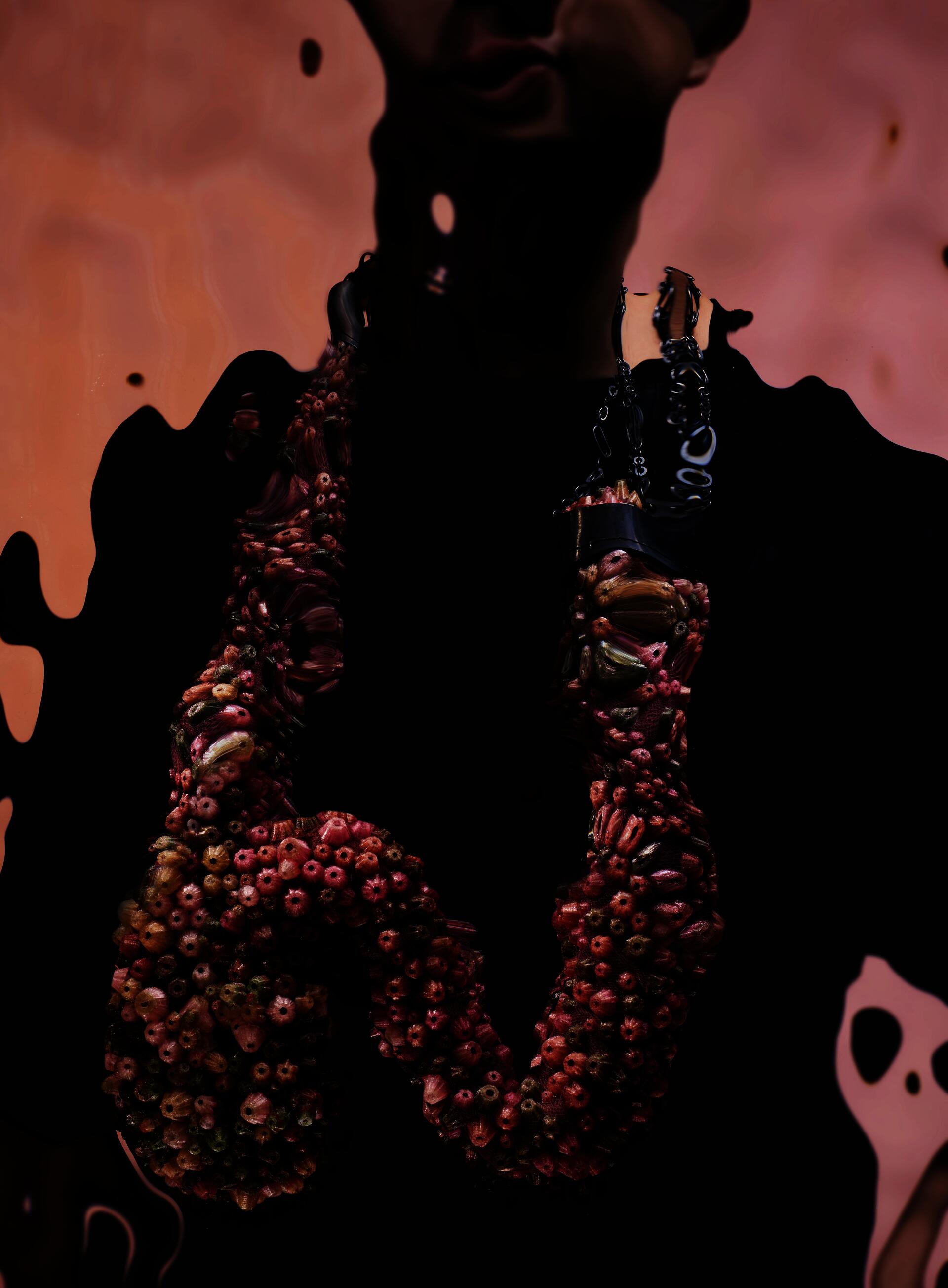 Large necklace covered in dense pink, green, and beige clustered forms on mesh, with an oxidized silver chain wrapping the upper section.