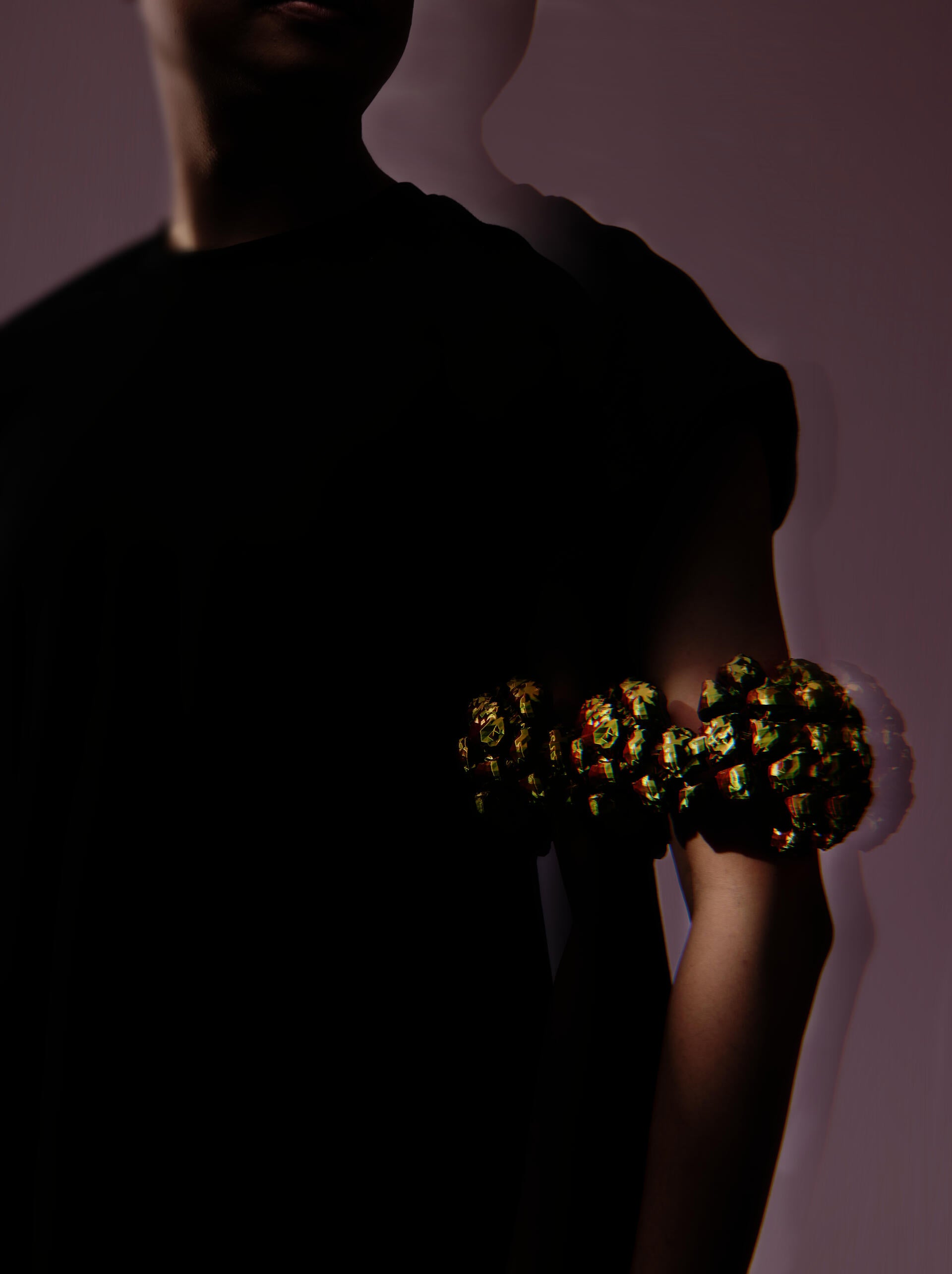Iridescent purple and pink arm cuff built from clustered rounded volumes that swell outward in a band.