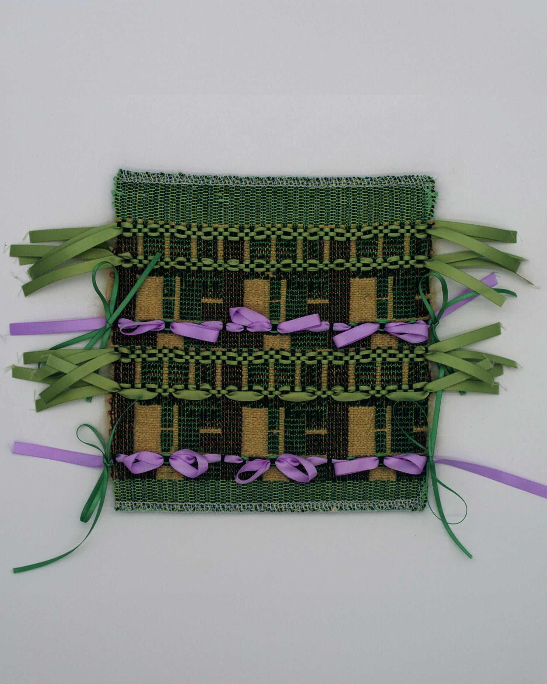 A woven fabric structured by a fragmented grid referencing the Halston House. Sage green and lilac ribbons are tied across the surface in bows, evoking architectural ornament