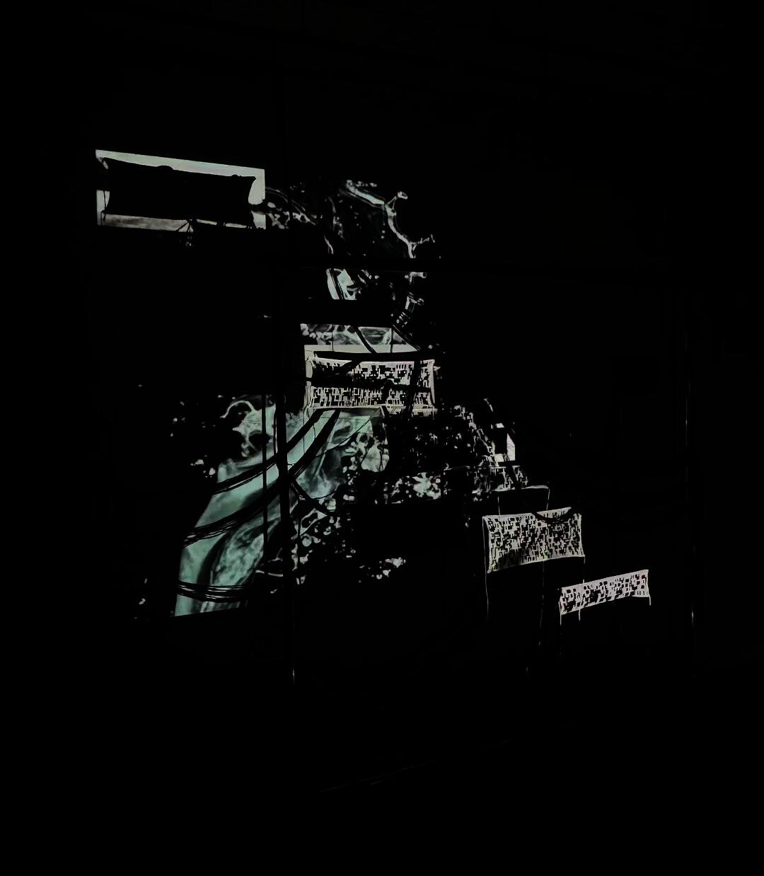 An installation featuring projection-mapped visuals of flowing, patterns inspired by Binary system across layered textile panels