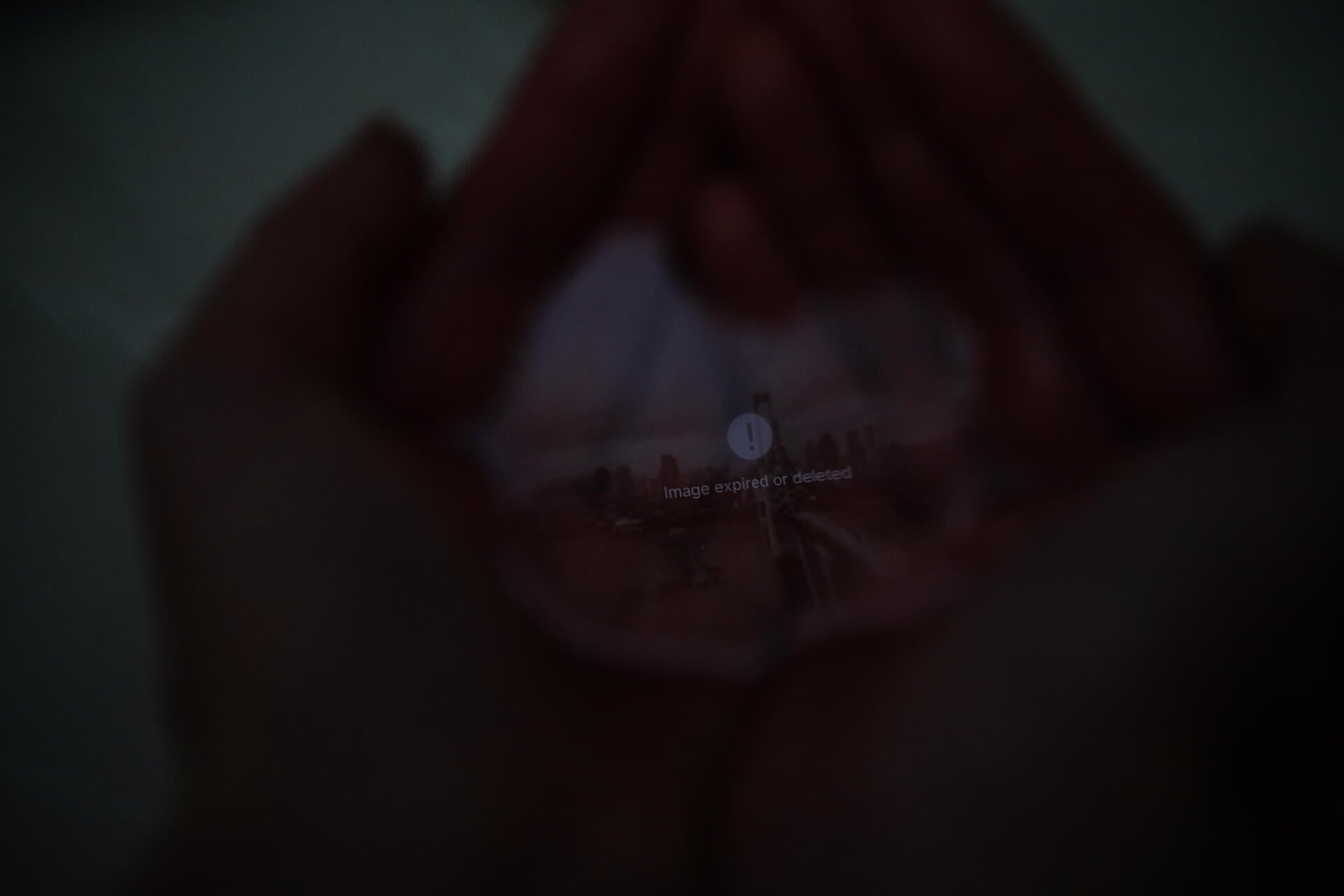 hands hold water with an image reflected on its surface; as the water continuously slips away, the image gradually disappears along with it.