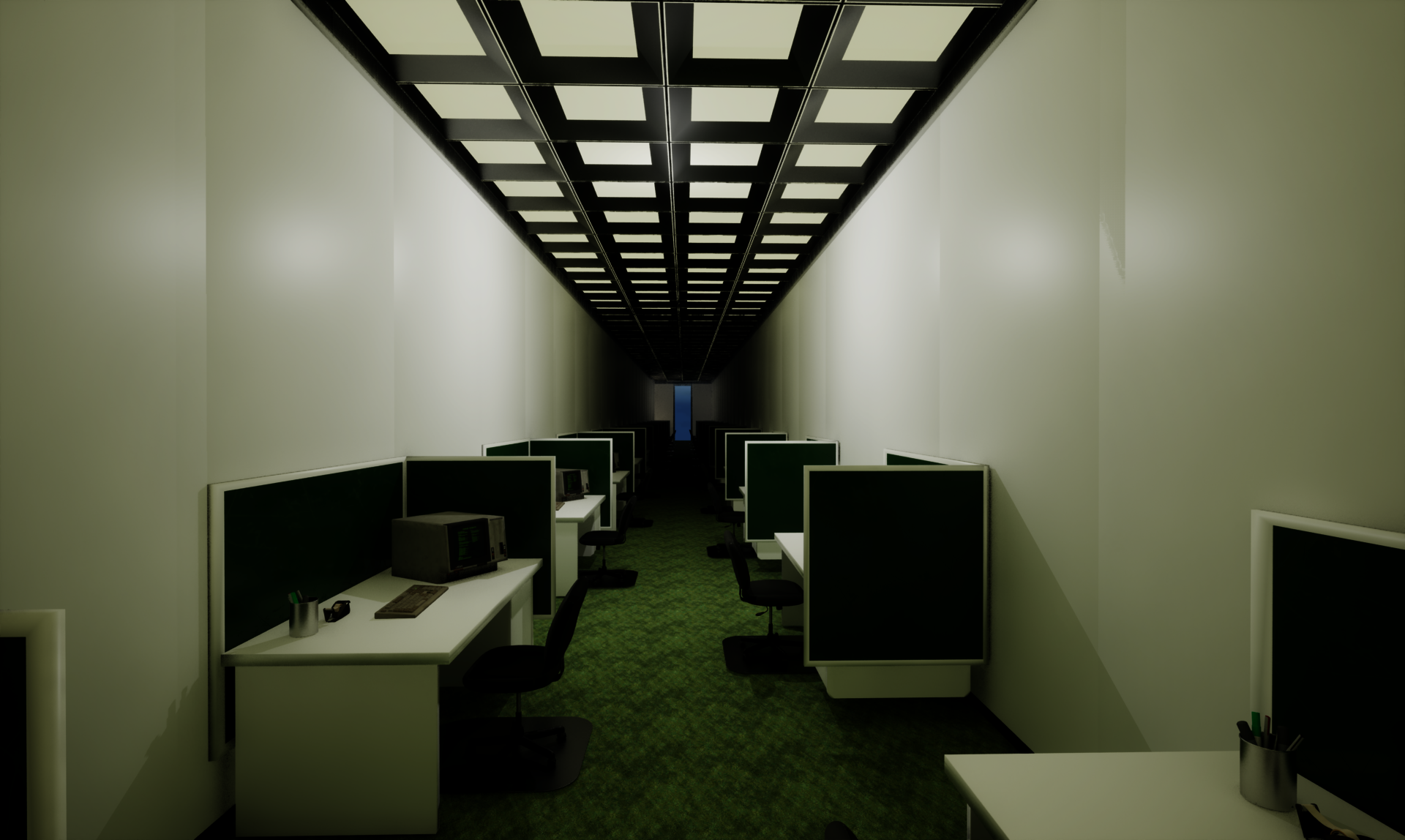 A long, narrow office with rows of green cubicles, desks and chairs, old computers, and bright ceiling lights leading toward a distant doorway.