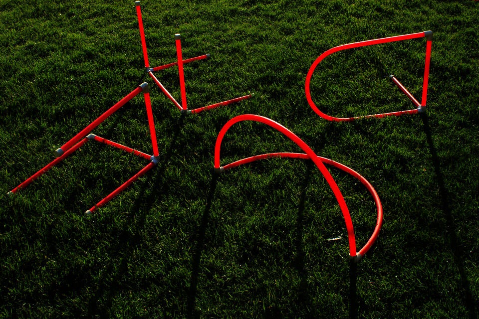 Photo of red PVC letterforms on grass