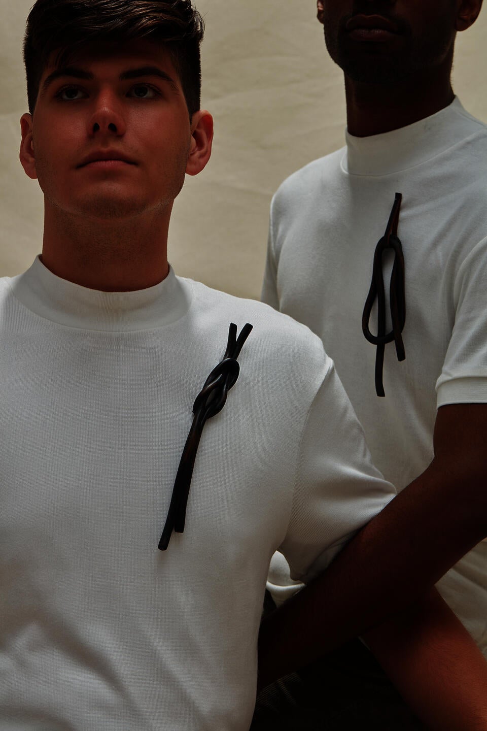 Two models wearing dark wooden knot brooches 