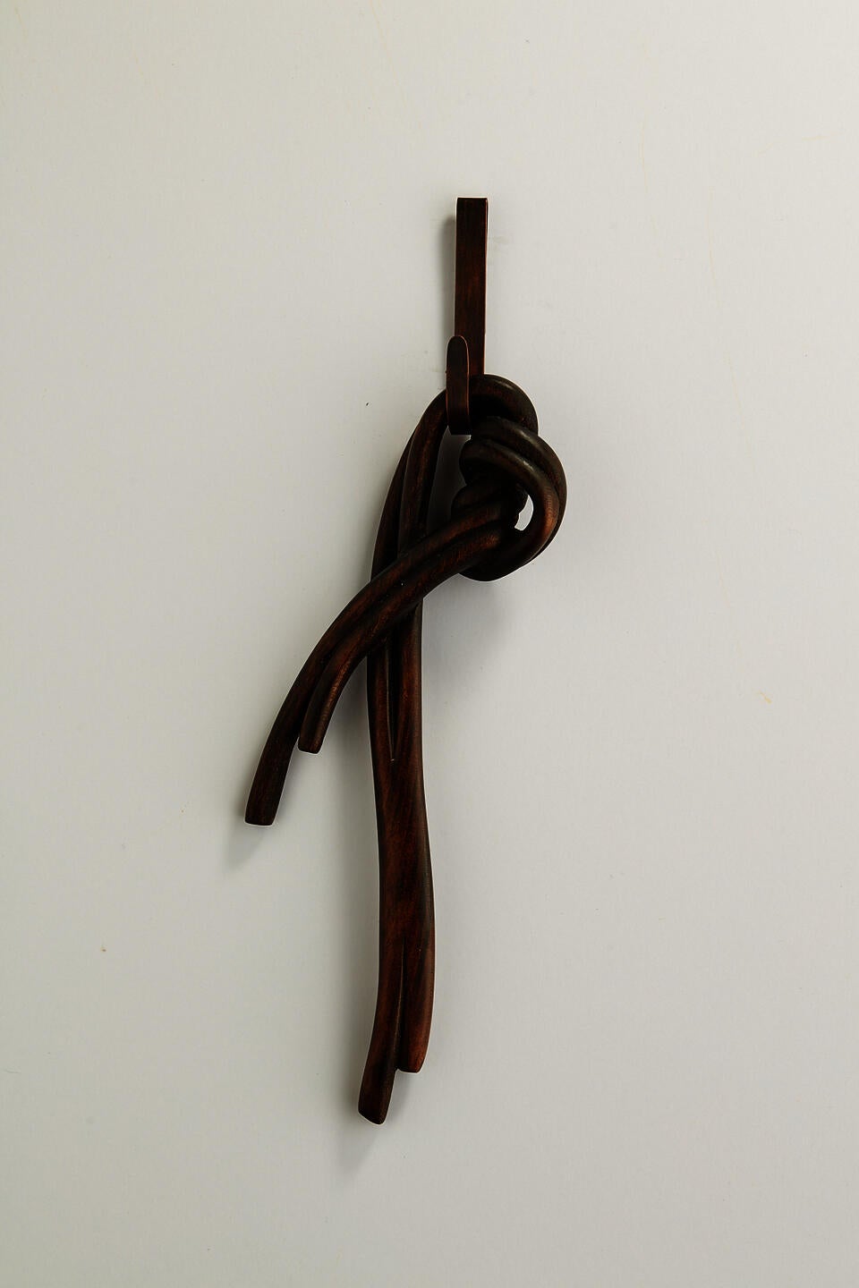 A dark knot brooch carved from wood
