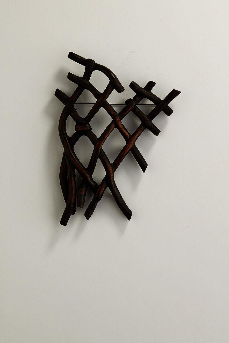 A dark knot brooch carved from wood