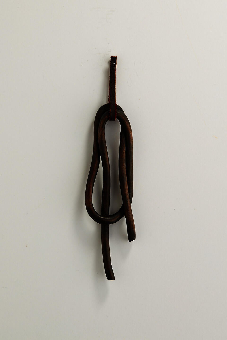 A dark knot brooch carved from wood