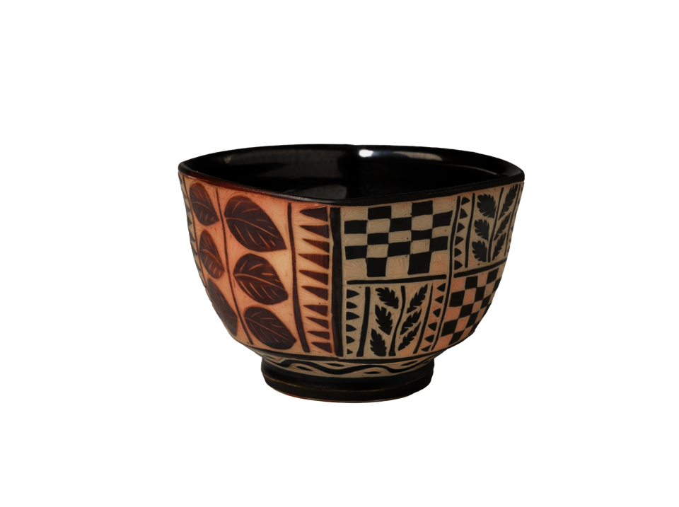 Square bowl with a circular foot. Black interior. Red leaves on either side of a single vine on the left side. Black and tan checkered and leaf decoration on the right side.