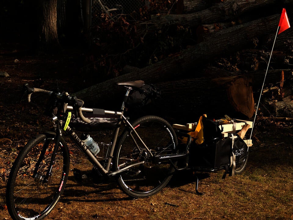 My bicycle and the trailer loaded up as my Manual Mobile Log Processing Unit in front of a pile of logs.