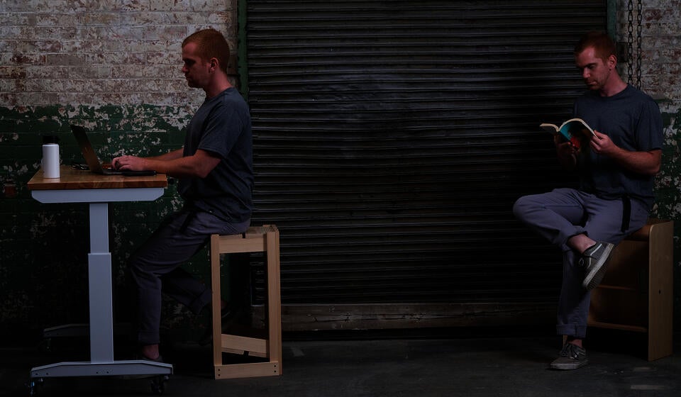 Photo of me seated on both versions of The Next One in its upside-down position.