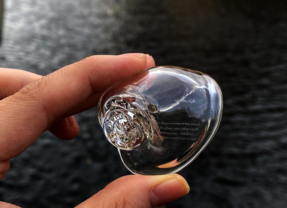 Hand hold a glass shell, you can see the poem on it 