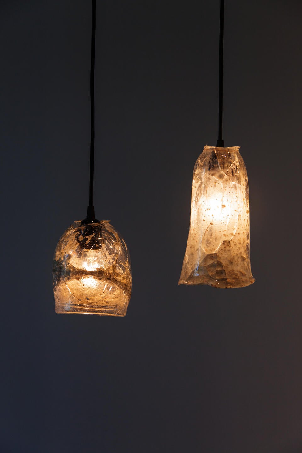 two hanging glass lamps made from glass of melted beach sand