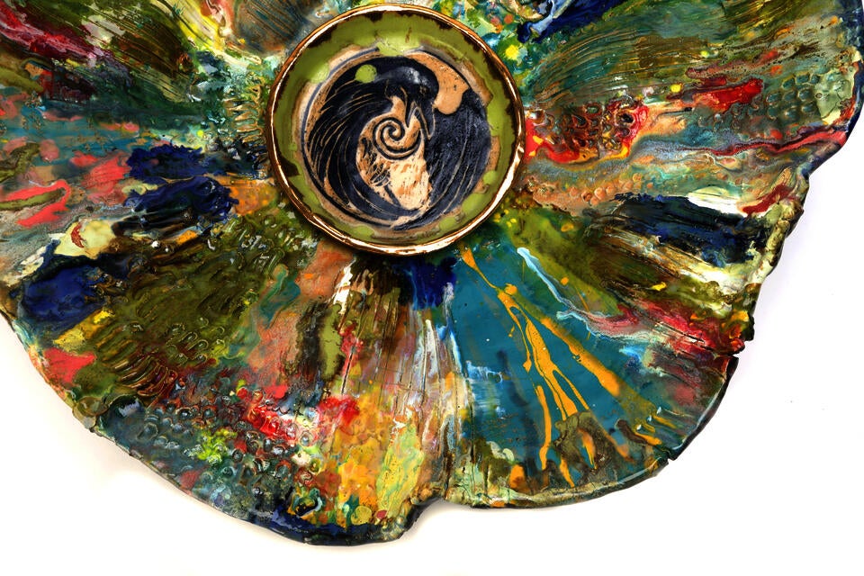 Colorful interior of large basin with illustration of raven in center. 