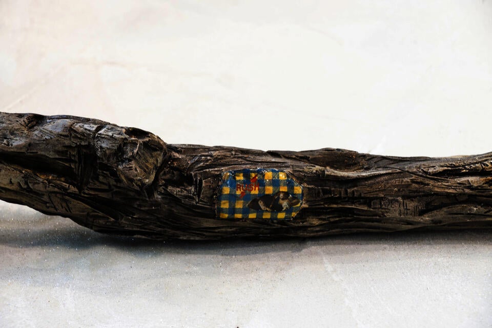 Detail of drift wood with patch of fabric depicting Saint Teresa in Ecstasy and the words "Rush". 