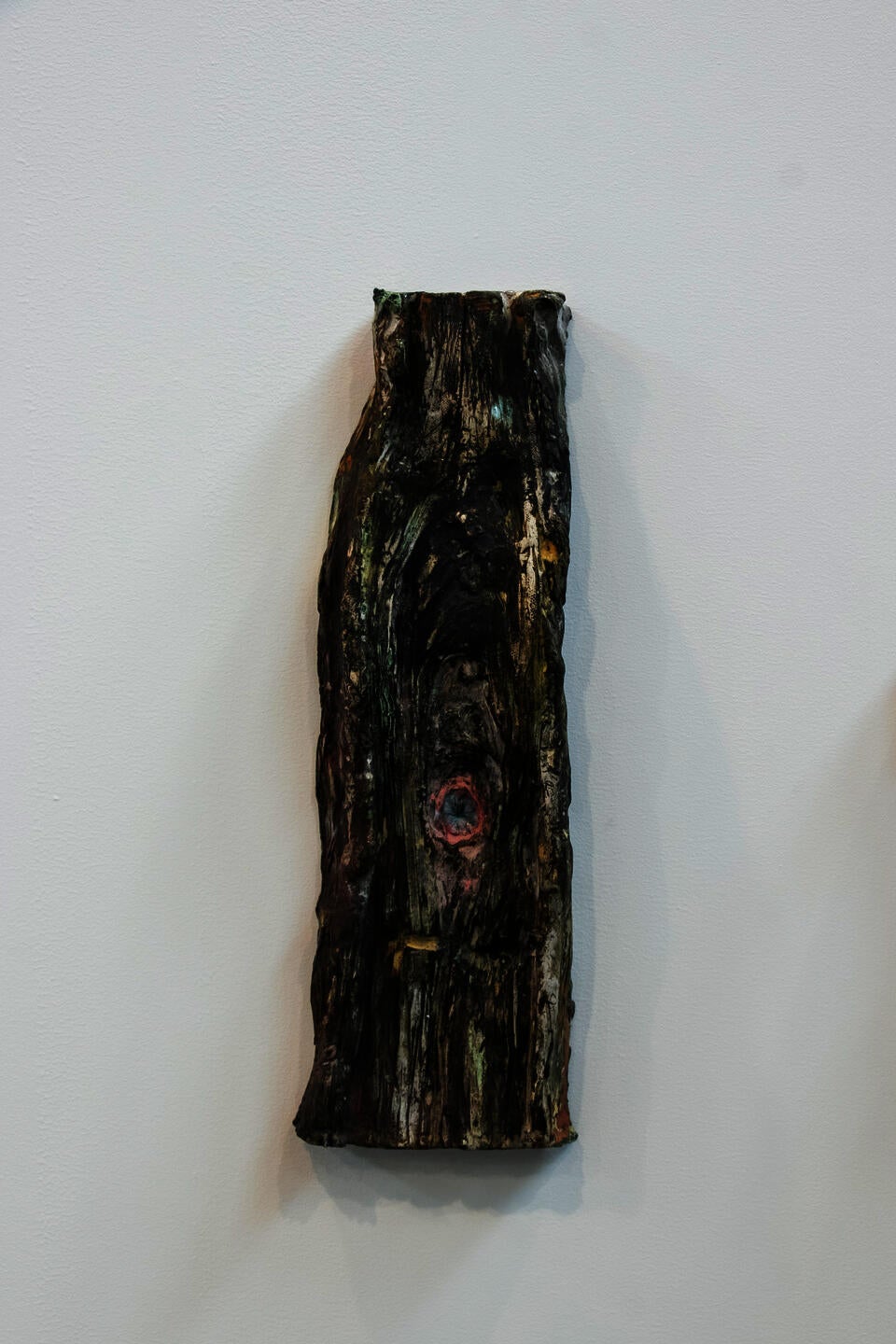Sculpted slice of a tree with a pink asshole in the center.