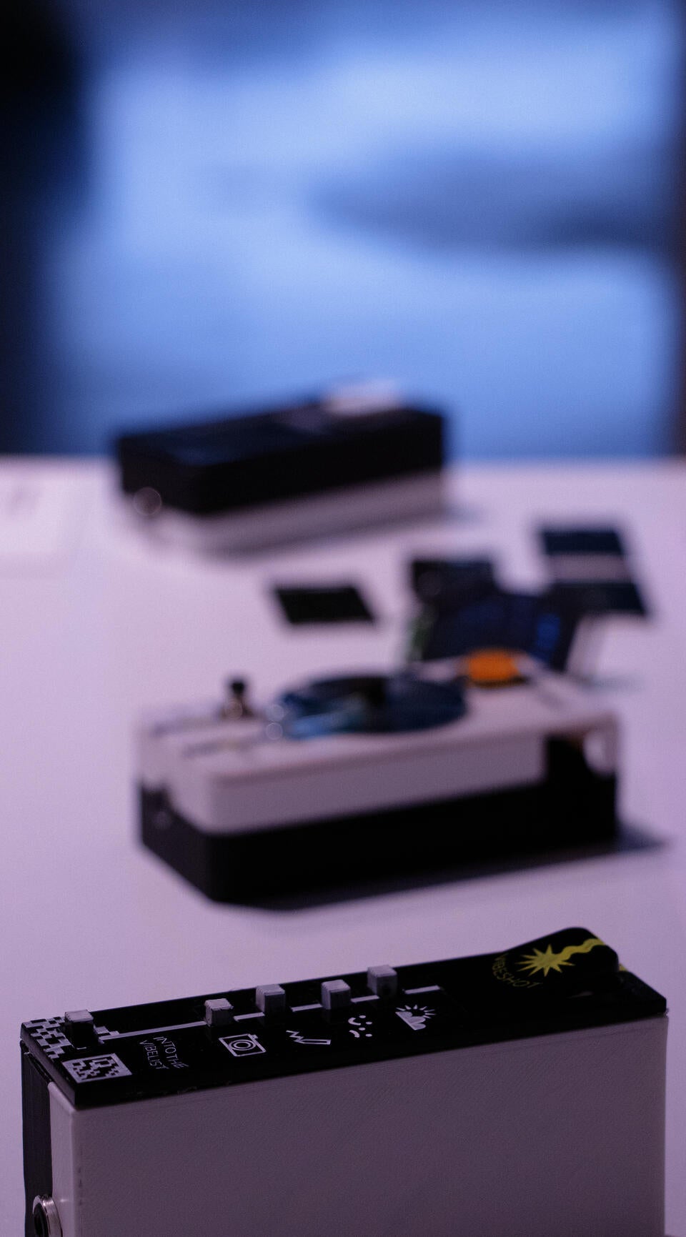 Portrait oriented photograph (vertical) showing the three devices. top to bottom: reaction tile, monofilter, vibelist. The vibelist is in focus, the rest are blurry.
