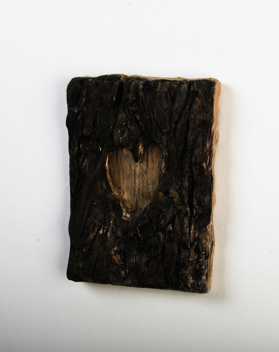 Clay sculpture of a heart cut out of tree