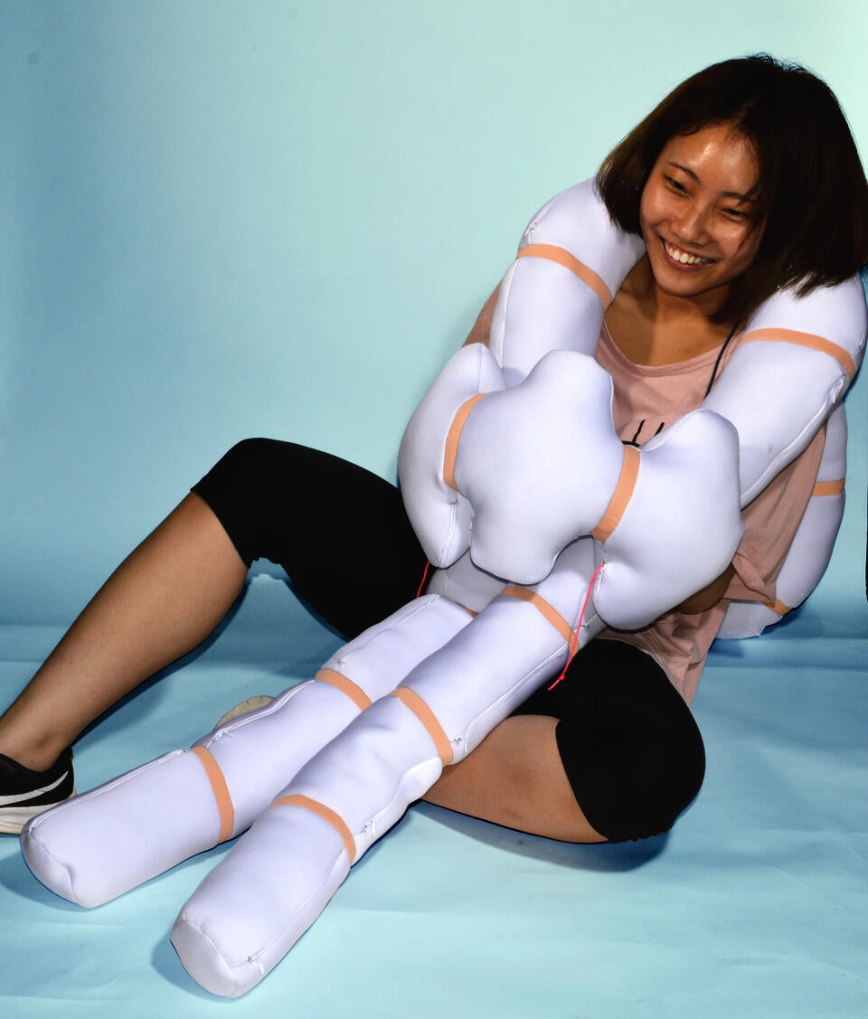 Color photograph, full body image with a girl playing with Nudo in blue background