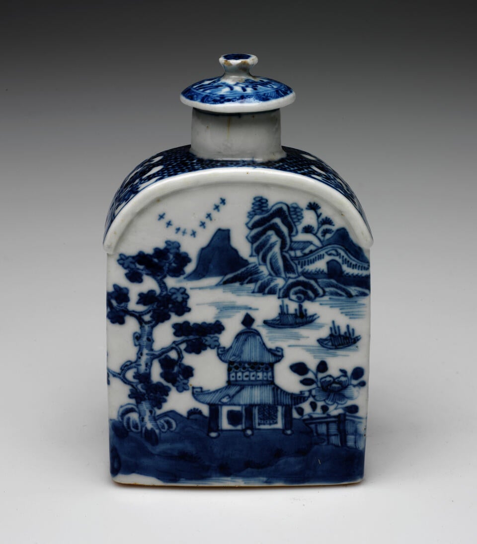 A rectangular vessel that curves at the top with blue and white decorations depicting architectural, floral, and landscape elements. The lid is circular and has a delicate finial.