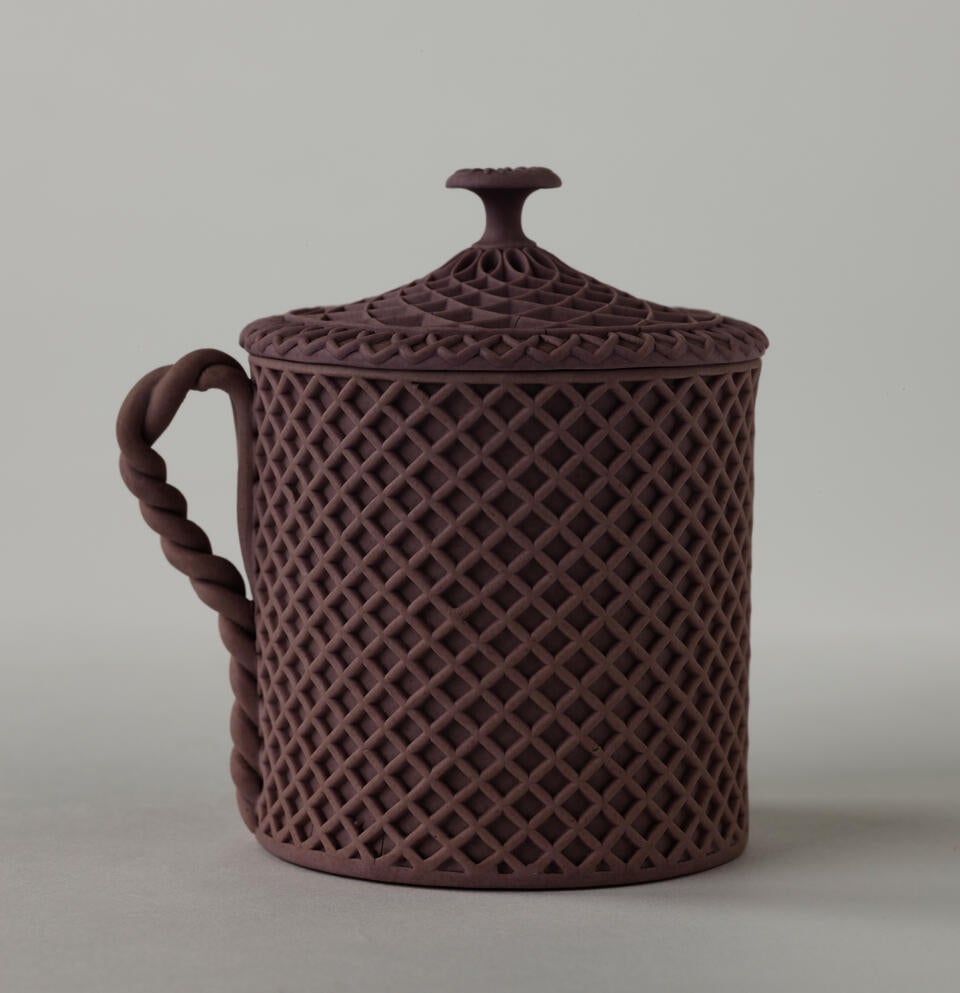 Jasperware custard cup with cover, the entire vessel and lid has a raised woven texture. The handle is sculptural and swirled.