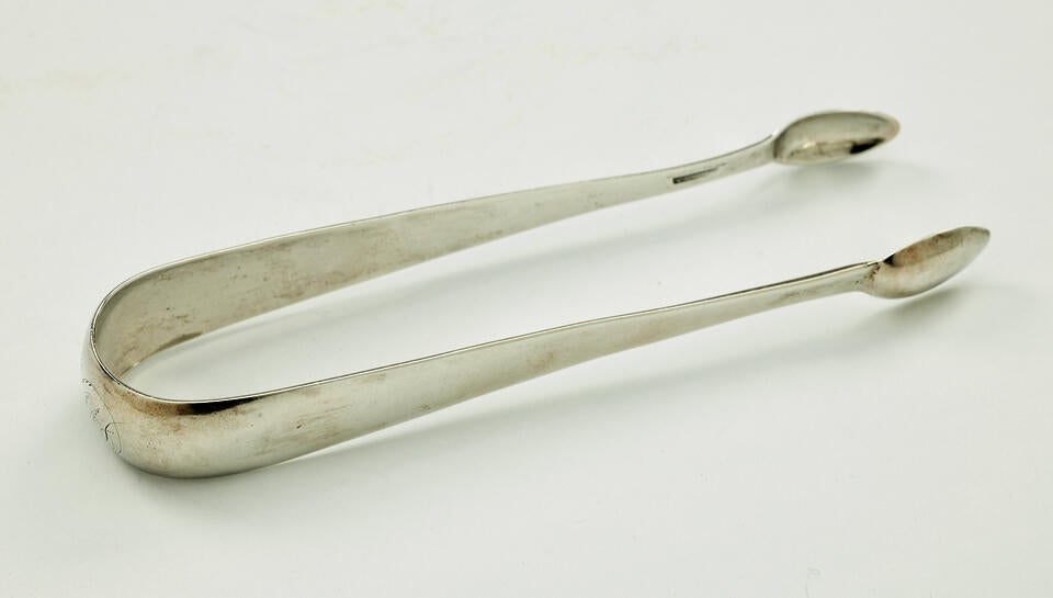 Silver sugar tongs with small ends and a thicker handle portion.