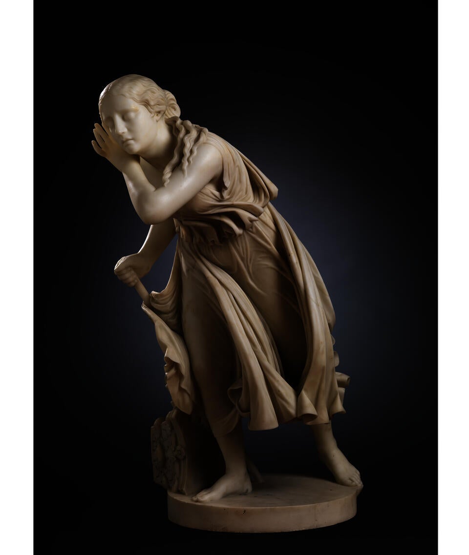 All-white sculpture of a young woman in a simple dress. She stands, weight on one foot, leaning forward attentively, a hand to her ear.