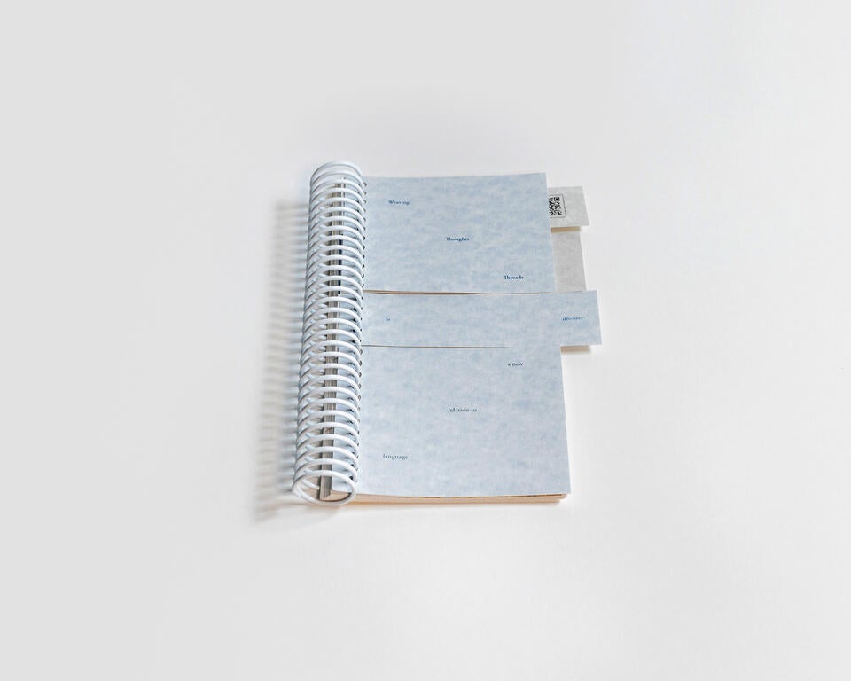 A photograph of a book that is cut in various sections to allow those who engage with it to randomly flip panels of text as they please. 