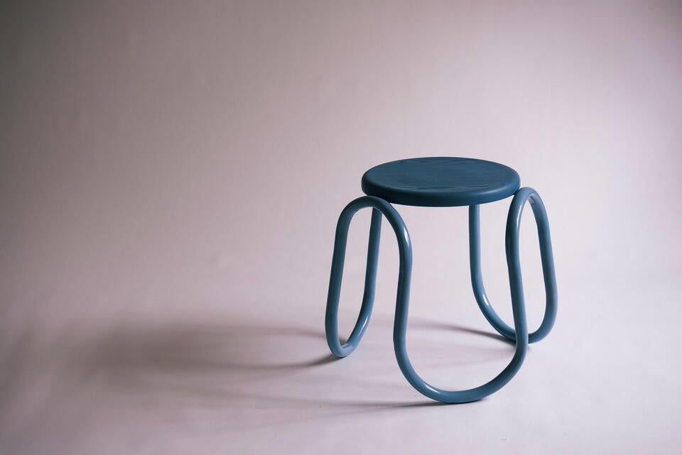A blue wiggly steel tube frame with a circle ash seat. 