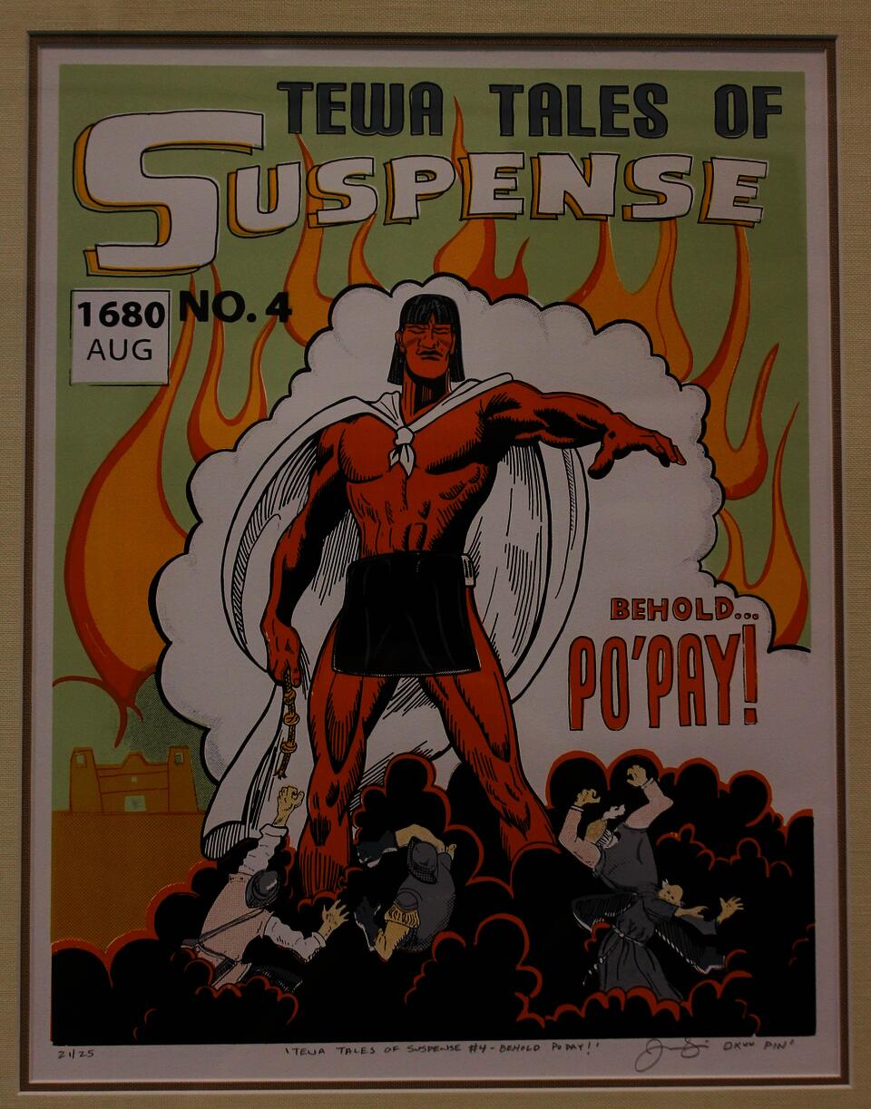 Jason Garcia's work Behold, Po'pay! is a serigraph print designed to look like a comic book cover featuring the protagonist, Po'pay, with a white cape towering over several Spanish soldiers and monks surrounded by a cloud of black smoke. Just behind Po'pay a billowing cloud of white smoke and orange flames outline his body in front of a pastel green background.