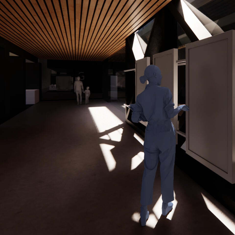 A rendering shows a woman standing in a brightly lit corridor in from of information screens; a man and child are walking at the end of the corridor.