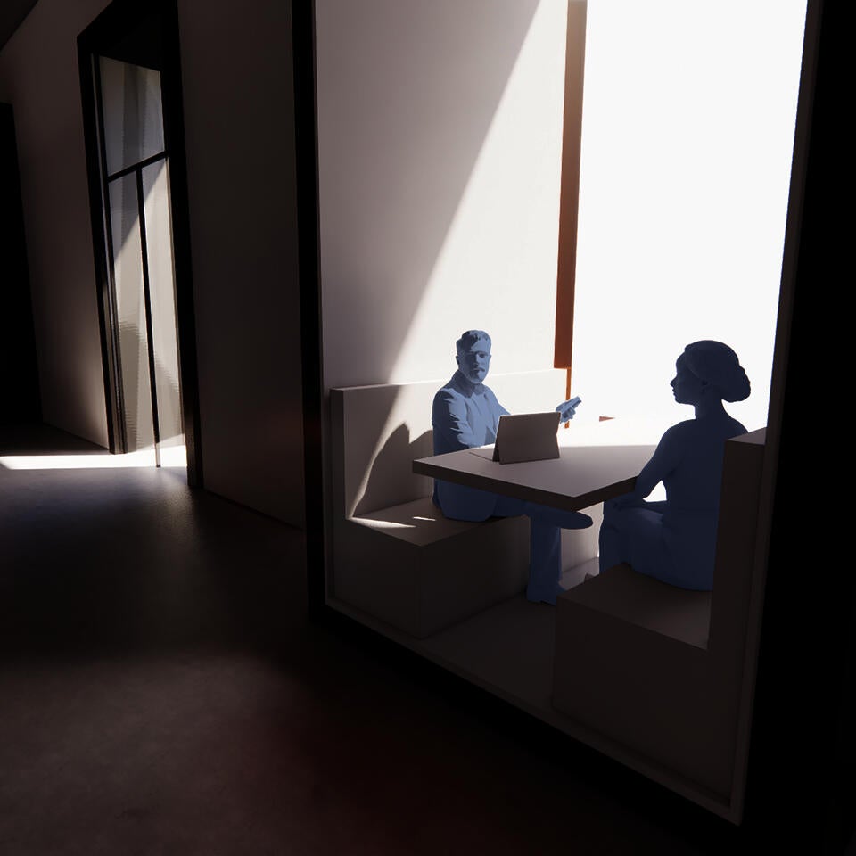 A man and woman sit reviewing a laptop in booth seating built into the frame of a very tall window.