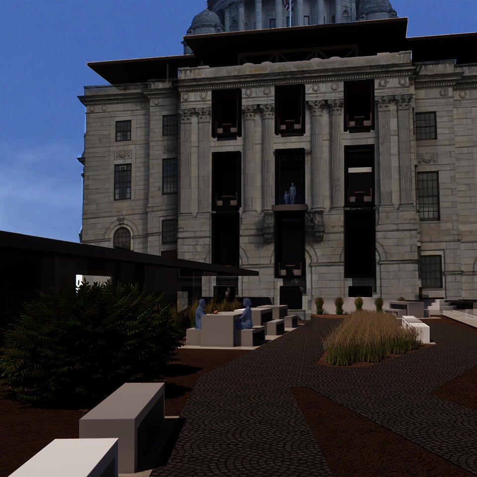 A bridge, hosting picnic tables and plantings, leads to the State House.