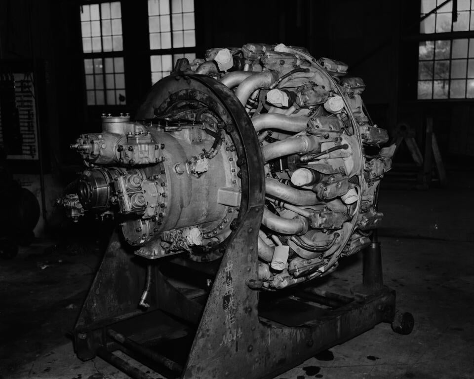 A black-and-white flash-lit photograph of the right-side posterior of a 1940's airplane engine.