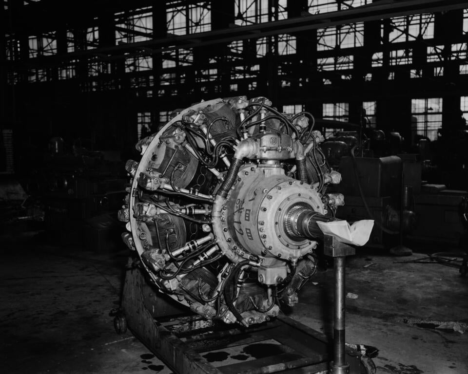 A black-and-white flash-lit photograph of the left-side posterior of a 1940's airplane engine.